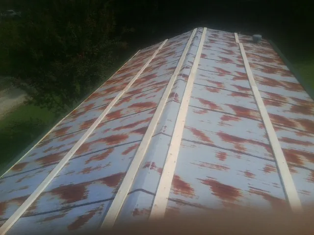 Rusted metal roof panels with new wood purlins before replacement — Storm Damage Roof Repair in Mc Calla by Roofing Brothers